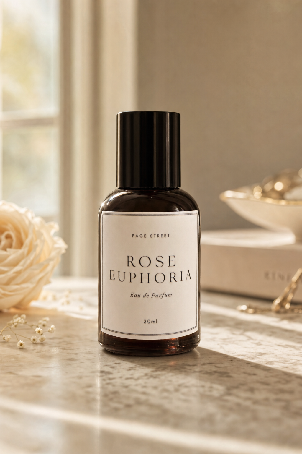 Bottle of 'Rose Euphoria' perfume on a marble surface with soft background